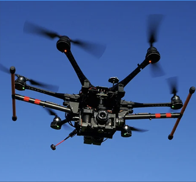Quad copter flying against blue sky